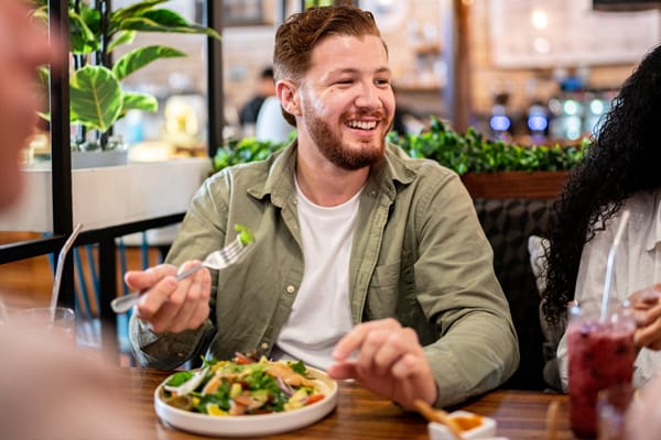A picture of a young male eating and smiling