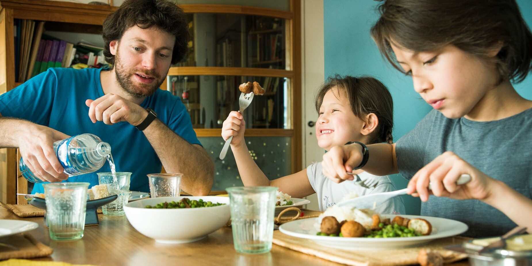 A photo of family of three having a meal together